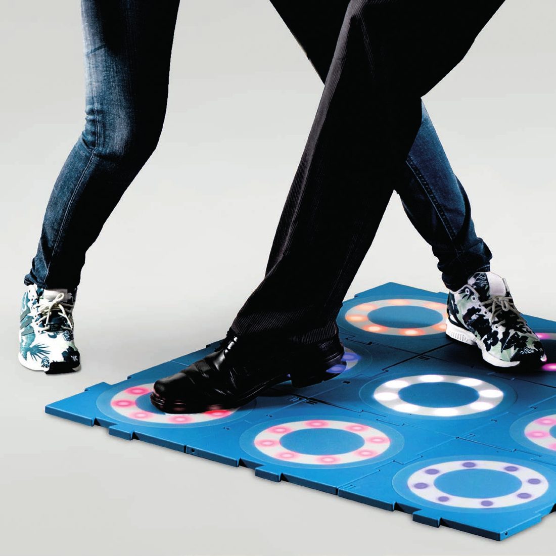 Two people stepping on lit MOTO tiles